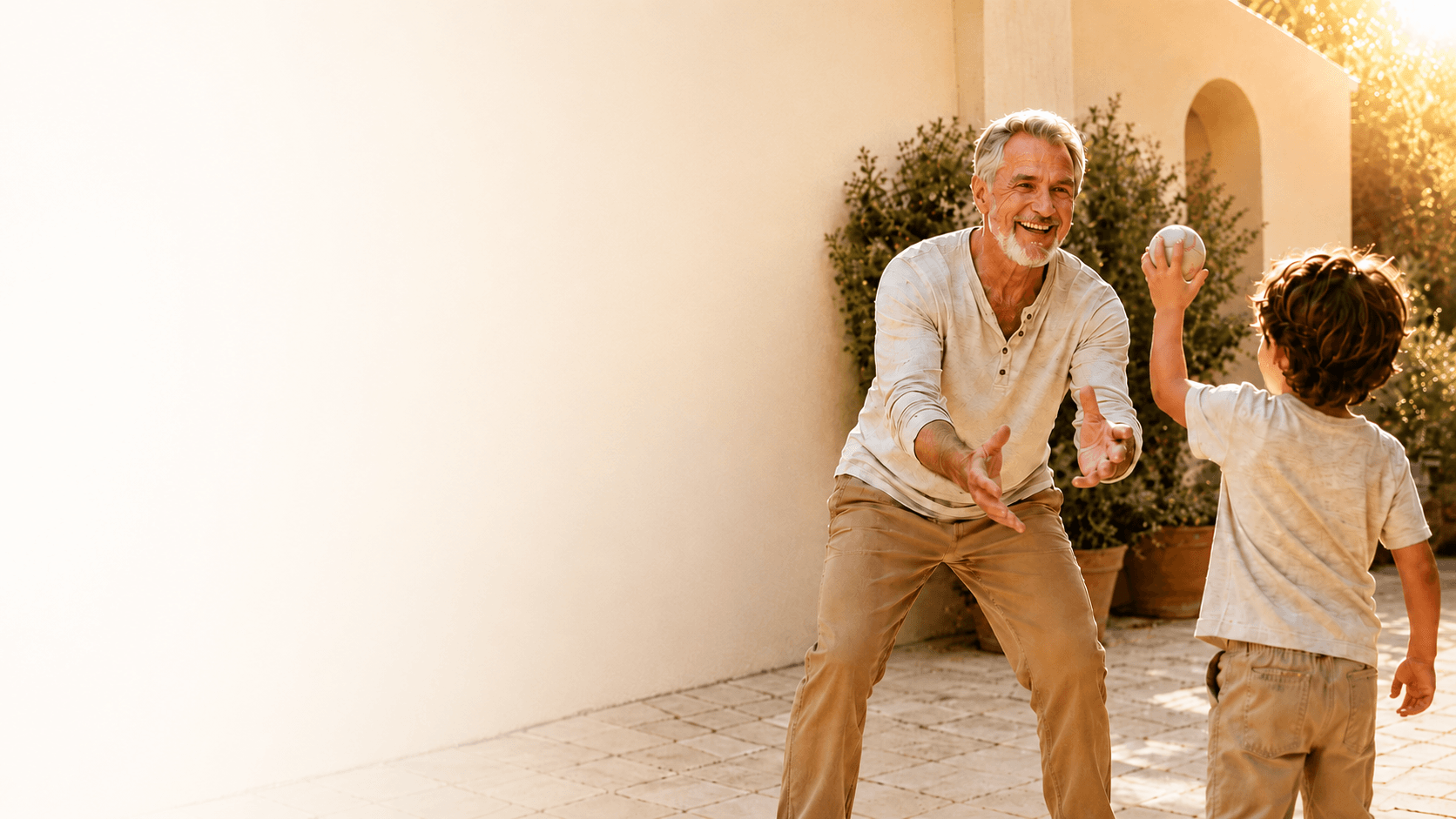 Grandfather playing catch with his grandson outdoors